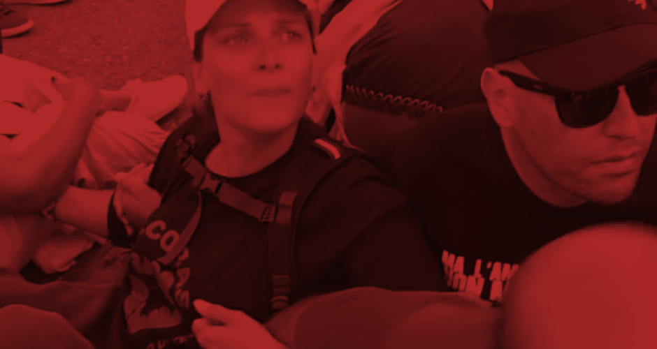 Sitzblockade vor Yoox Frau mit SICobas T-Shirt und Mann bei einer Sitzblockade, untergehakt, vor dem Warenlager der Firma Yoox, vertreten durch die Kooperative Mr. Job in Bologna, Italien