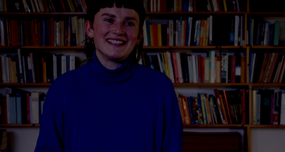 Aktivistin im Interview vor Bücherwand