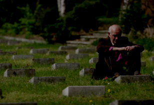 Sohn eines der in Treuenbrietzen von der Wehrmacht ermordeten Italienischen Kriegsinternierten sitzt auf dem Friedhof vor dem Grab seines Vaters