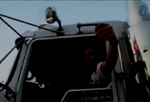 Glücklicher LKW Fahrer spricht durch das Fenster von seinem LKW aus